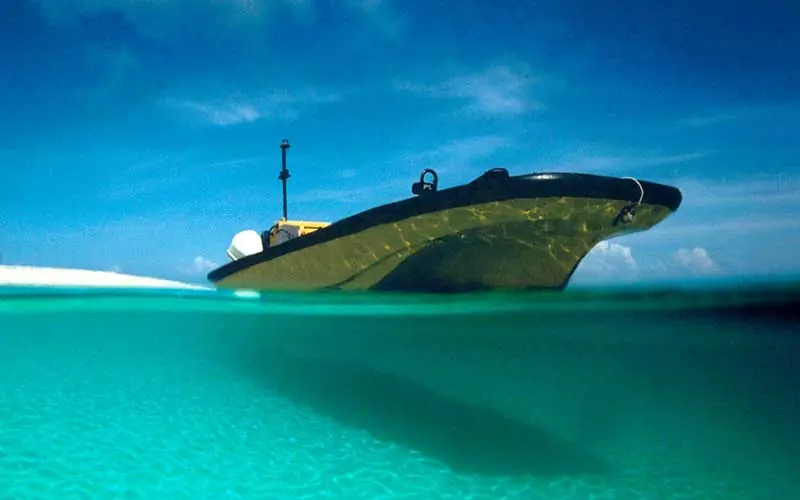 Traditional wooden dhow boat half submerged in turquoise water, Fundu Lagoon, Zanzibar & Pemba, Tanzania