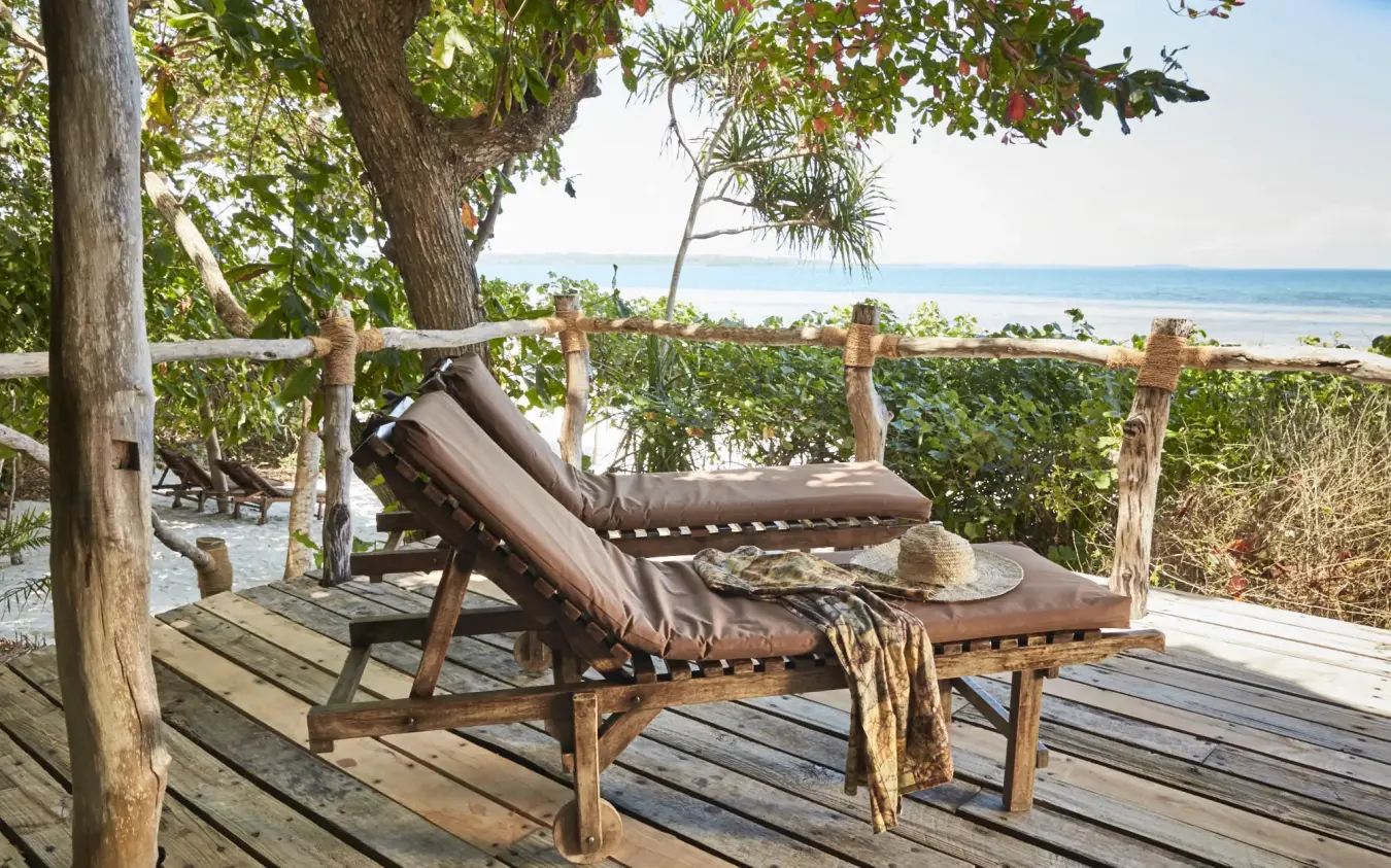 Wooden deck with loungers overlooking tropical beach and ocean, Fundu Lagoon, Zanzibar & Pemba, Tanzania