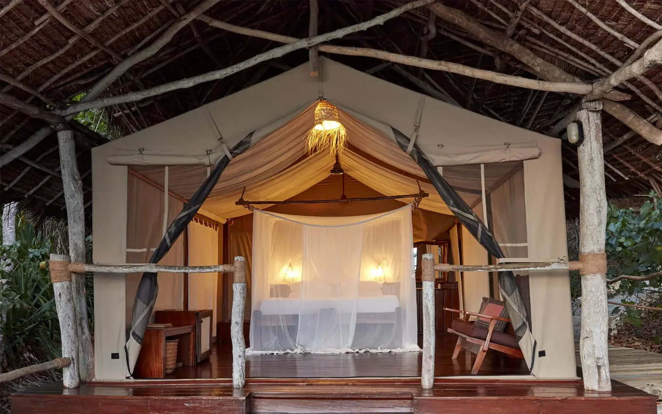 Illuminated canvas tent with draped entrance at dusk, Fundu Lagoon, Zanzibar & Pemba, Tanzania