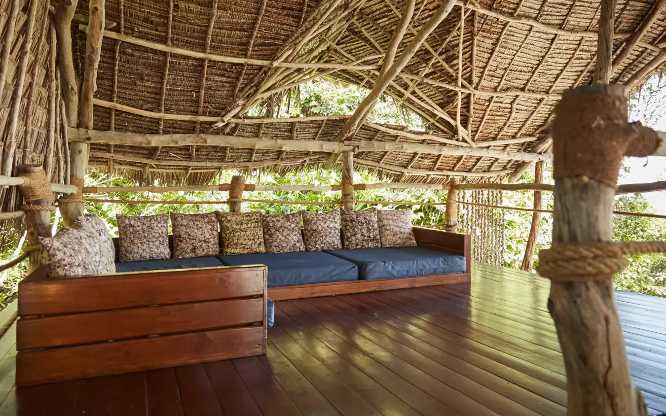 Thatched pavilion with wooden deck seating and cushions, Fundu Lagoon, Zanzibar & Pemba, Tanzania