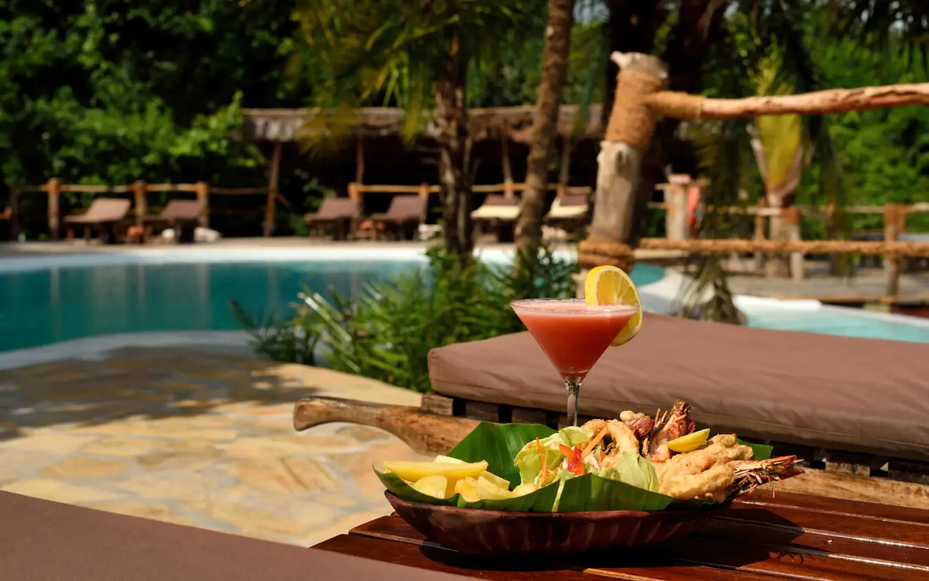 Cocktail and grilled seafood by poolside lounge area, Fundu Lagoon, Zanzibar & Pemba, Tanzania