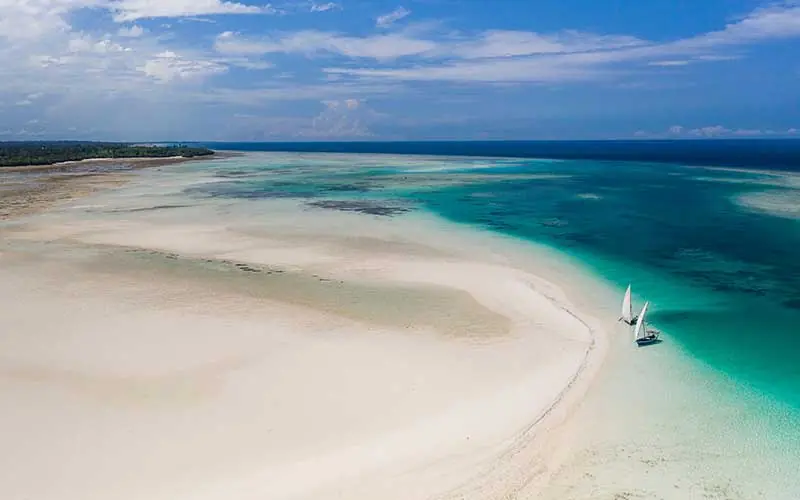 Sailboat anchored in shallow turquoise lagoon waters, Fundu Lagoon, Zanzibar & Pemba, Tanzania