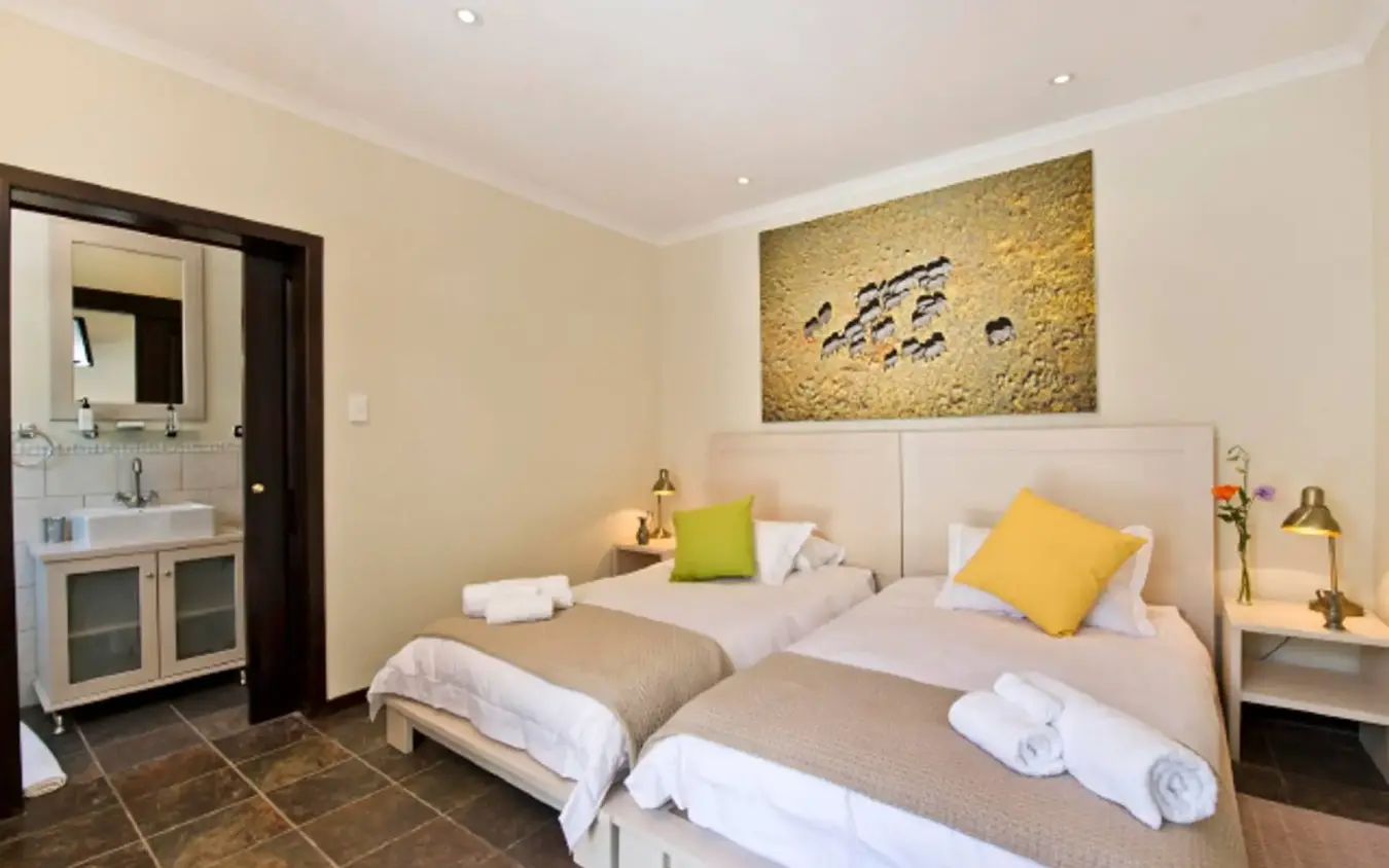 Twin beds in spacious bedroom with ensuite bathroom visible, Galton House, Windhoek, Namibia