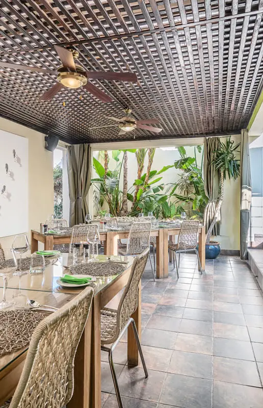 Indoor dining area with fireplace and garden views, Galton House, Windhoek, Namibia