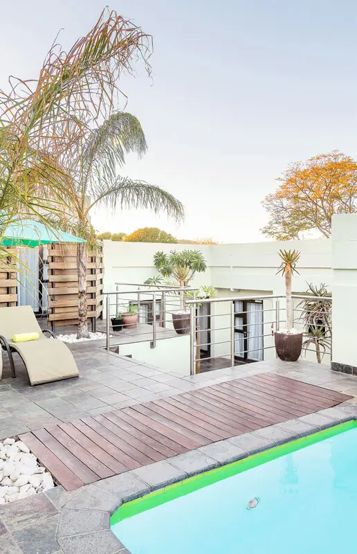 Rooftop pool area with loungers and palm trees, Galton House, Windhoek, Namibia