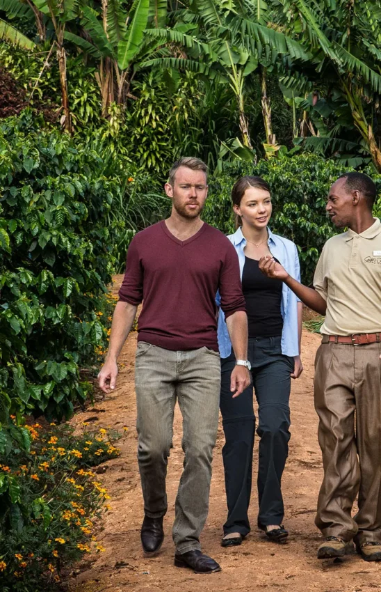 Three people walking through lush garden pathways together, Gibb’s Farm, Ngorongoro Crater, Tanzania