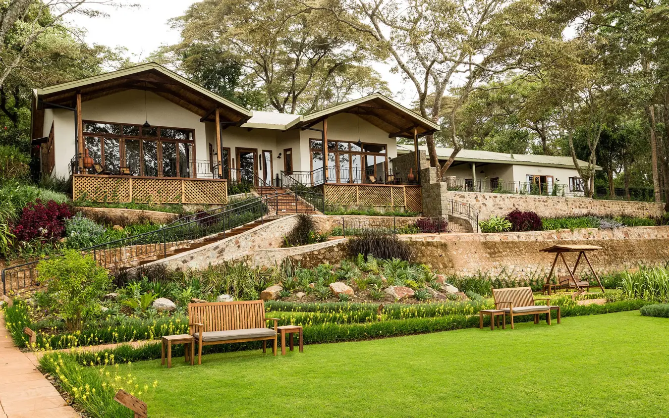 Hillside lodge buildings with manicured gardens and seating areas, Gibb’s Farm, Ngorongoro Crater, Tanzania
