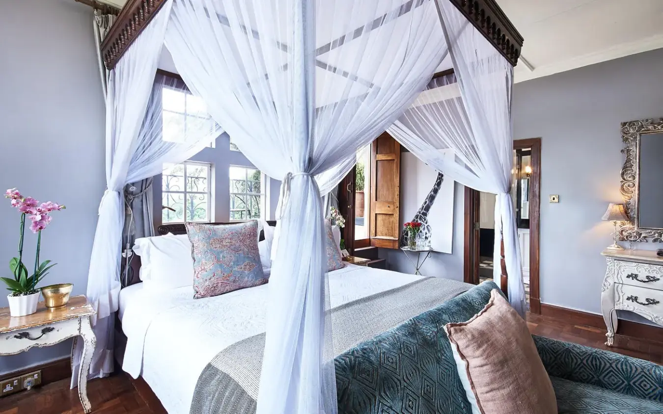 Luxurious four-poster bed with flowing white curtains and window view, Giraffe Manor, Nairobi, Kenya