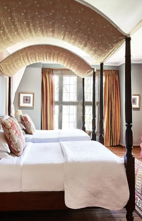 Four-poster bed in elegantly appointed bedroom with arched ceiling, Giraffe Manor, Nairobi, Kenya