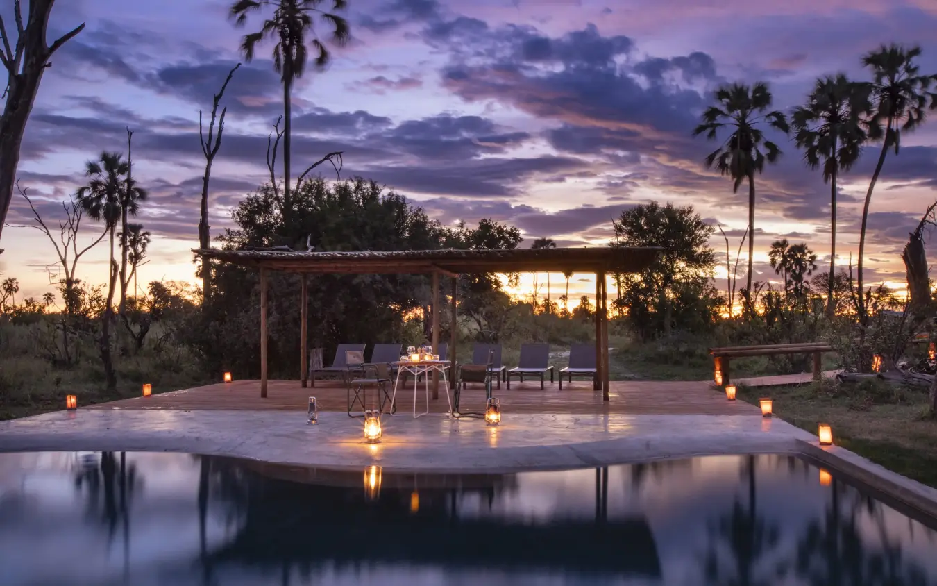Circular deck with dining setup overlooking water at dusk, Gomoti Plains, The Okavango Delta, Botswana