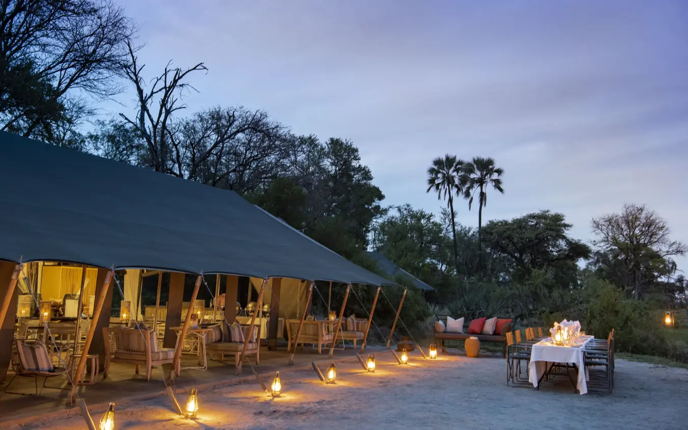 Canvas tent dining area at dusk with lantern lighting, Gomoti Plains, The Okavango Delta, Botswana