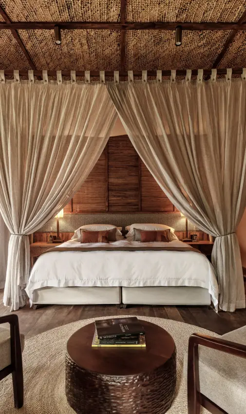 Canopy bedroom with draped four-poster bed and seating area, Gorilla Forest Lodge, Bwindi Impenetrable Forest, Uganda