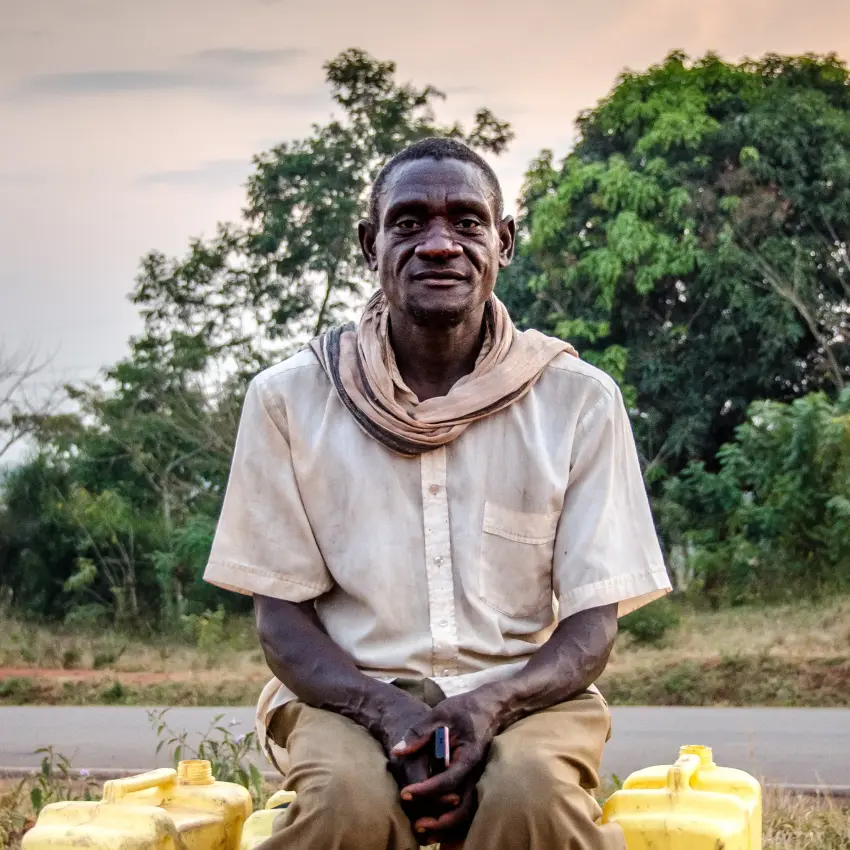 Portrait of man in light colored shirt with trees in background, Lake Kivu, Rwanda