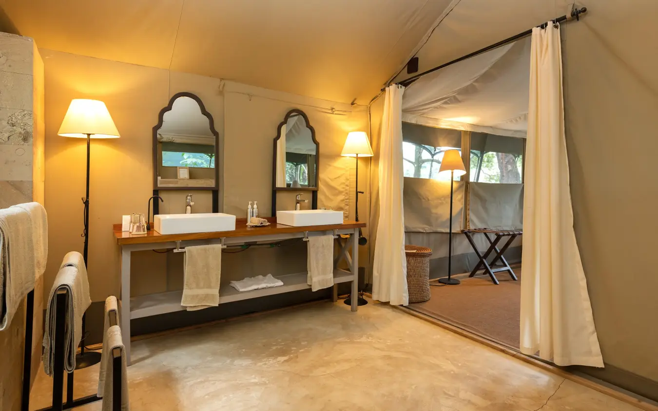 Luxury safari tent bathroom with dual vanities and canvas walls, Governors’ Camp, Maasai Mara, Kenya
