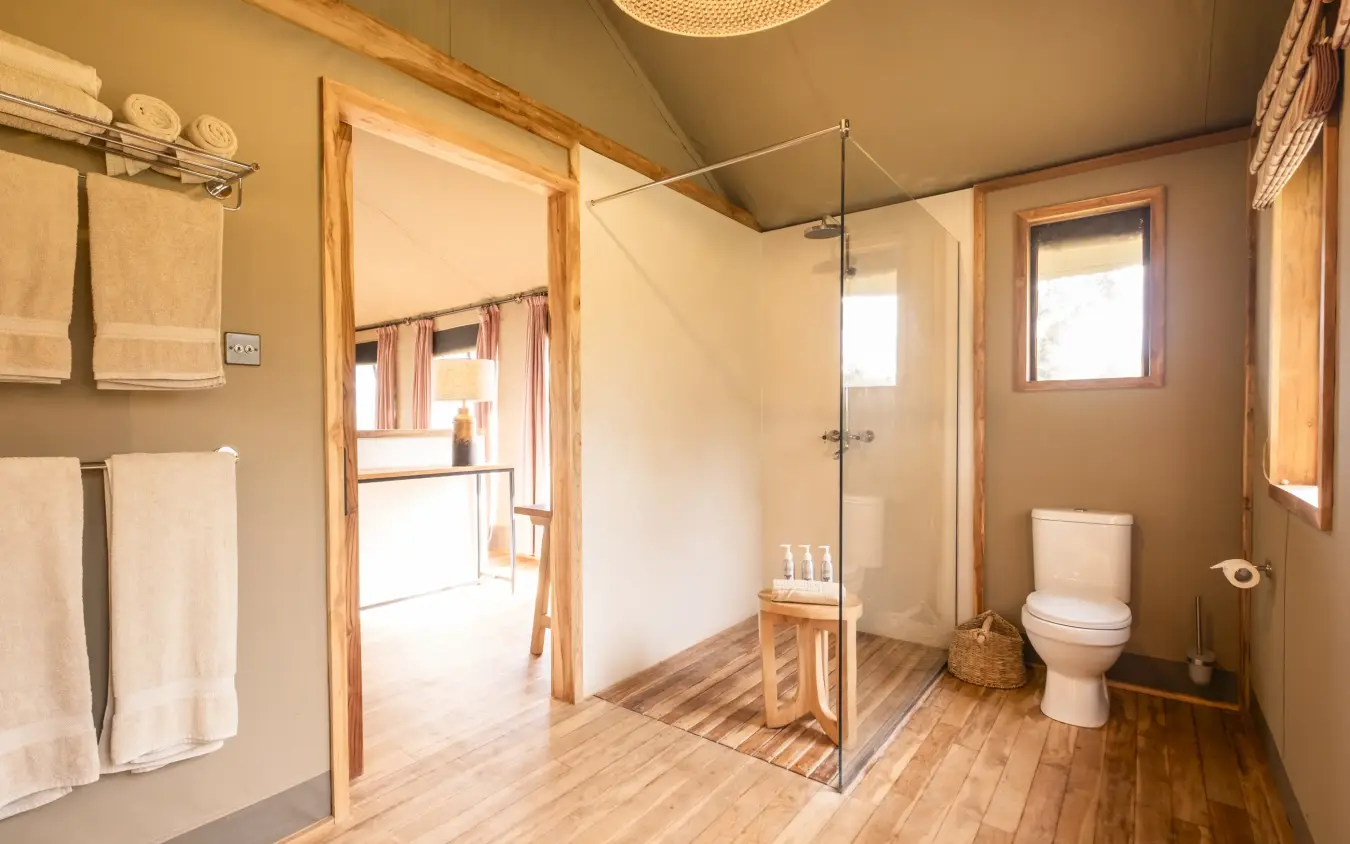 Spacious bathroom with walk-in shower and wooden finishes, Governors’ Camp, Maasai Mara, Kenya