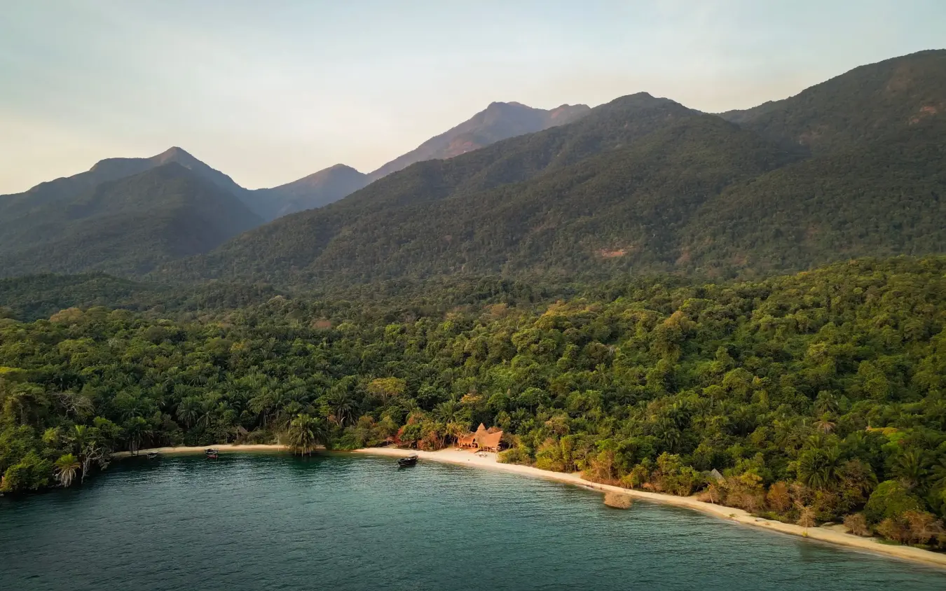 Tropical beach cove with forested mountains and turquoise water, Greystoke Mahale, Mahale Mountains, Tanzania