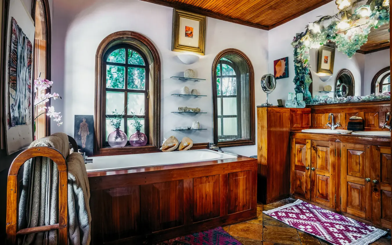 Luxurious bathroom with wooden paneling and arched windows, Hemingways Eden Residence, Nairobi, Kenya