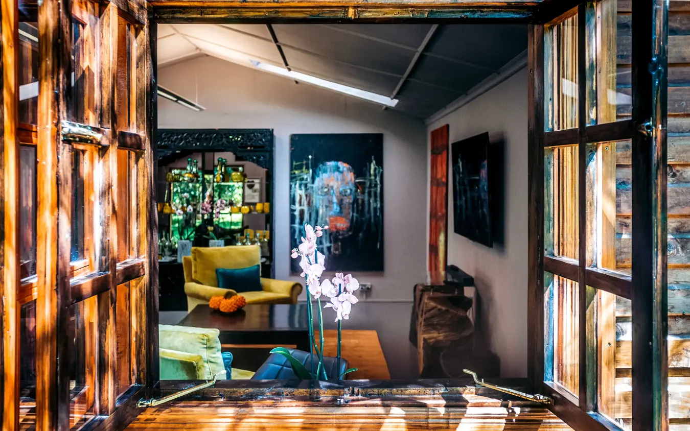 Open wooden doors framing interior lounge with artwork, Hemingways Eden Residence, Nairobi, Kenya