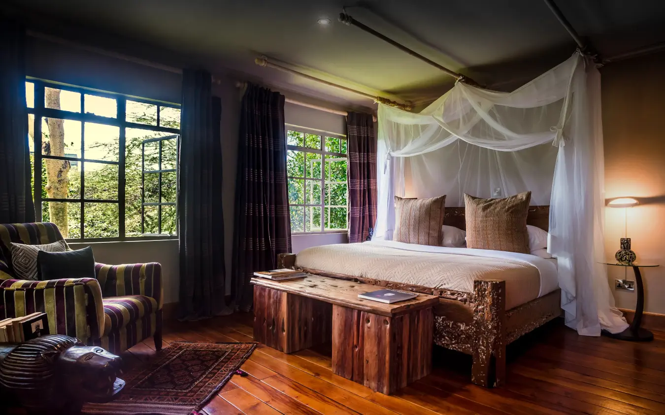 Luxury bedroom with canopy bed and large windows overlooking forest, Hemingways Eden Residence, Nairobi, Kenya