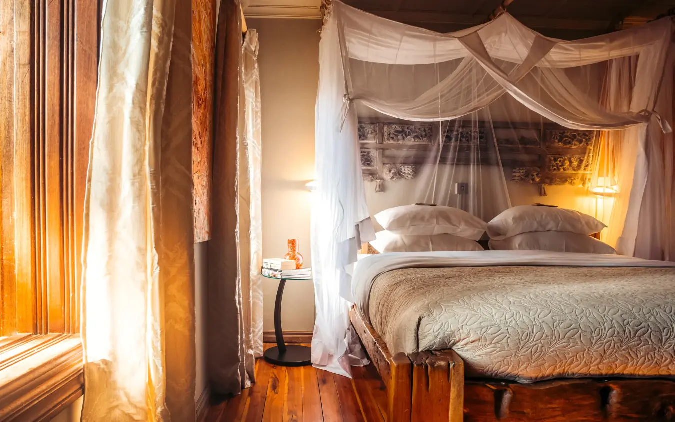 Bedroom with canopy bed and warm evening lighting, Hemingways Eden Residence, Nairobi, Kenya