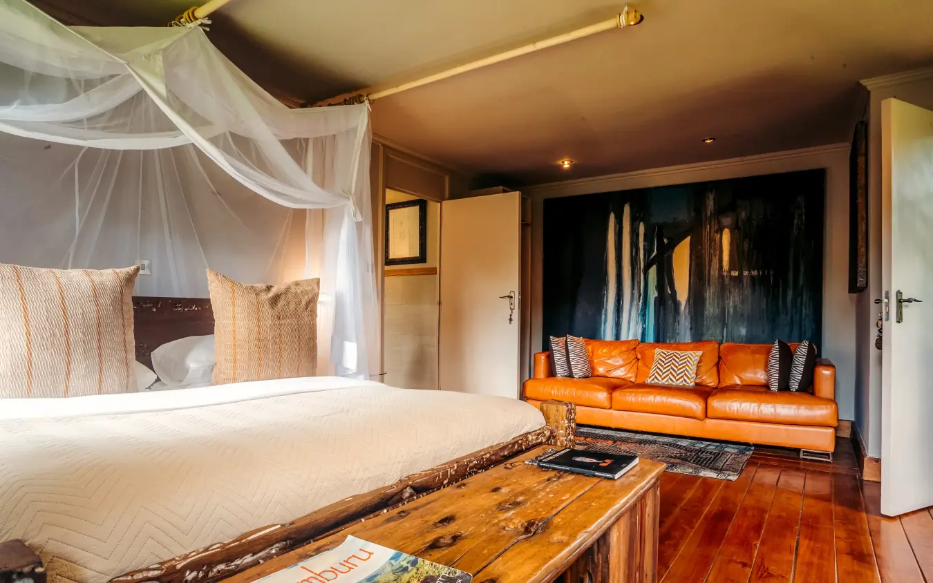 Luxury bedroom with canopy bed and orange seating area, Hemingways Eden Residence, Nairobi, Kenya