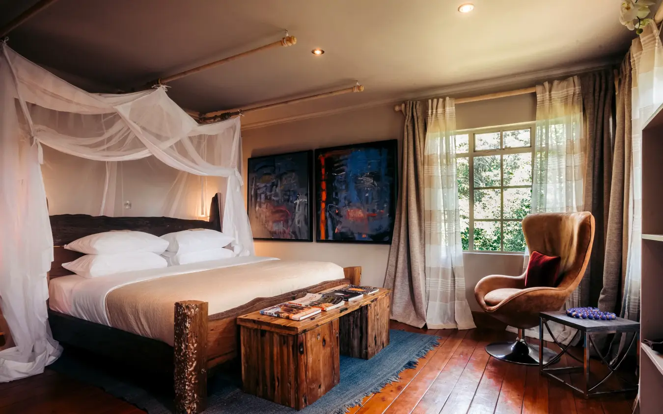 Luxury bedroom with canopy bed and lounge seating area, Hemingways Eden Residence, Nairobi, Kenya