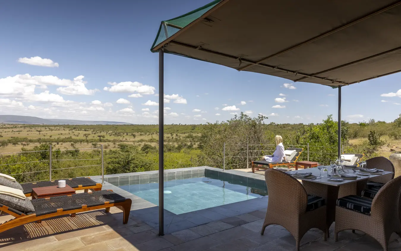 Pool deck with shade structure overlooking vast savanna landscape, Hemingways Ol Seki Mara, Maasai Mara, Kenya