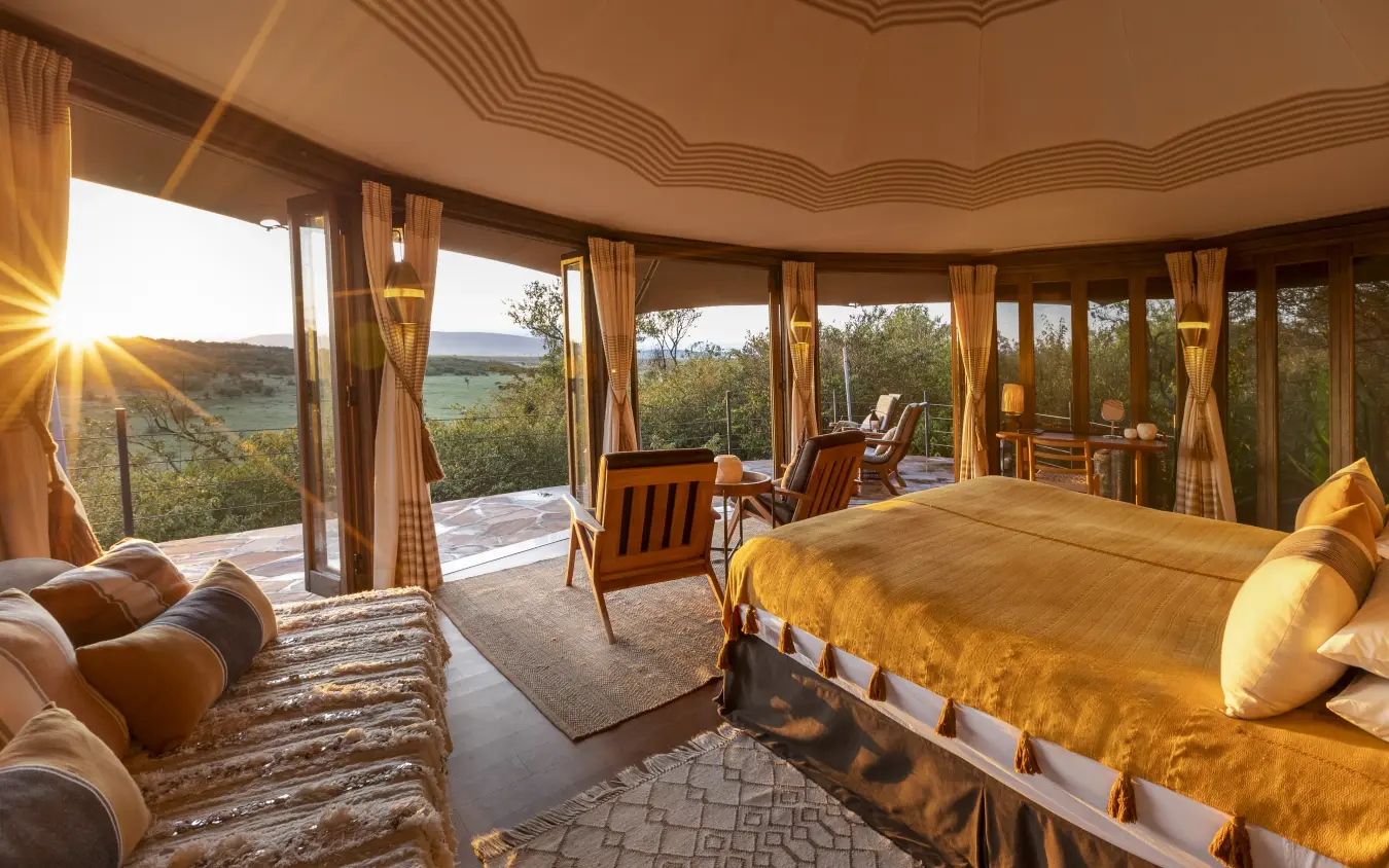 Luxury bedroom suite with panoramic windows overlooking savanna landscape at sunset, Hemingways Ol Seki Mara, Maasai Mara, Kenya