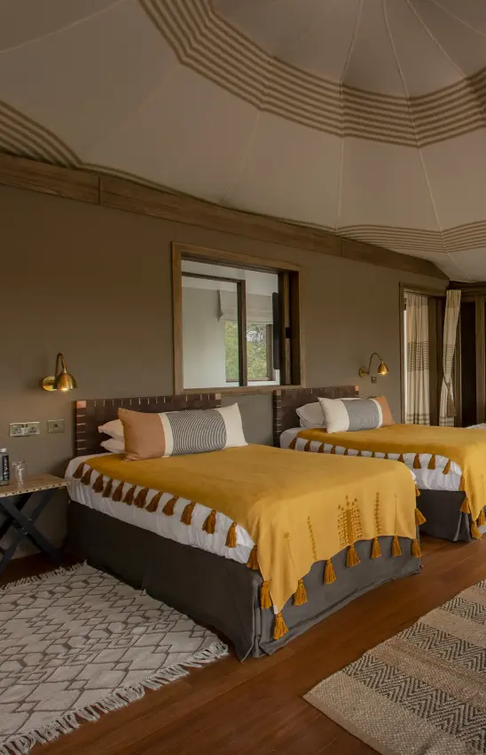 Twin beds with golden throws in safari lodge bedroom with domed ceiling, Hemingways Ol Seki Mara, Maasai Mara, Kenya