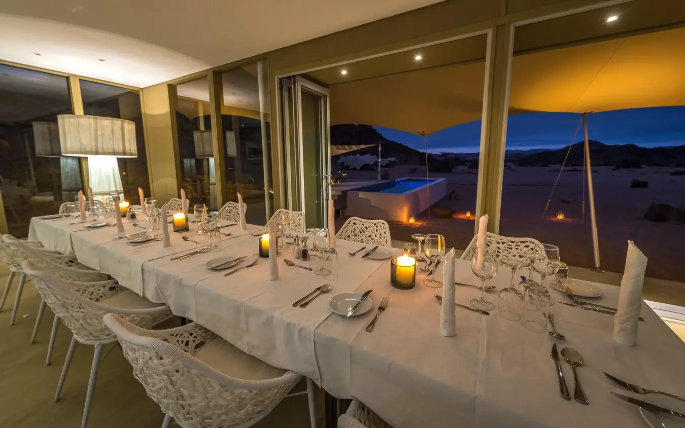 Fine dining table set with ocean view at dusk, Hoanib Skeleton Coast Camp, Skeleton Coast, Namibia