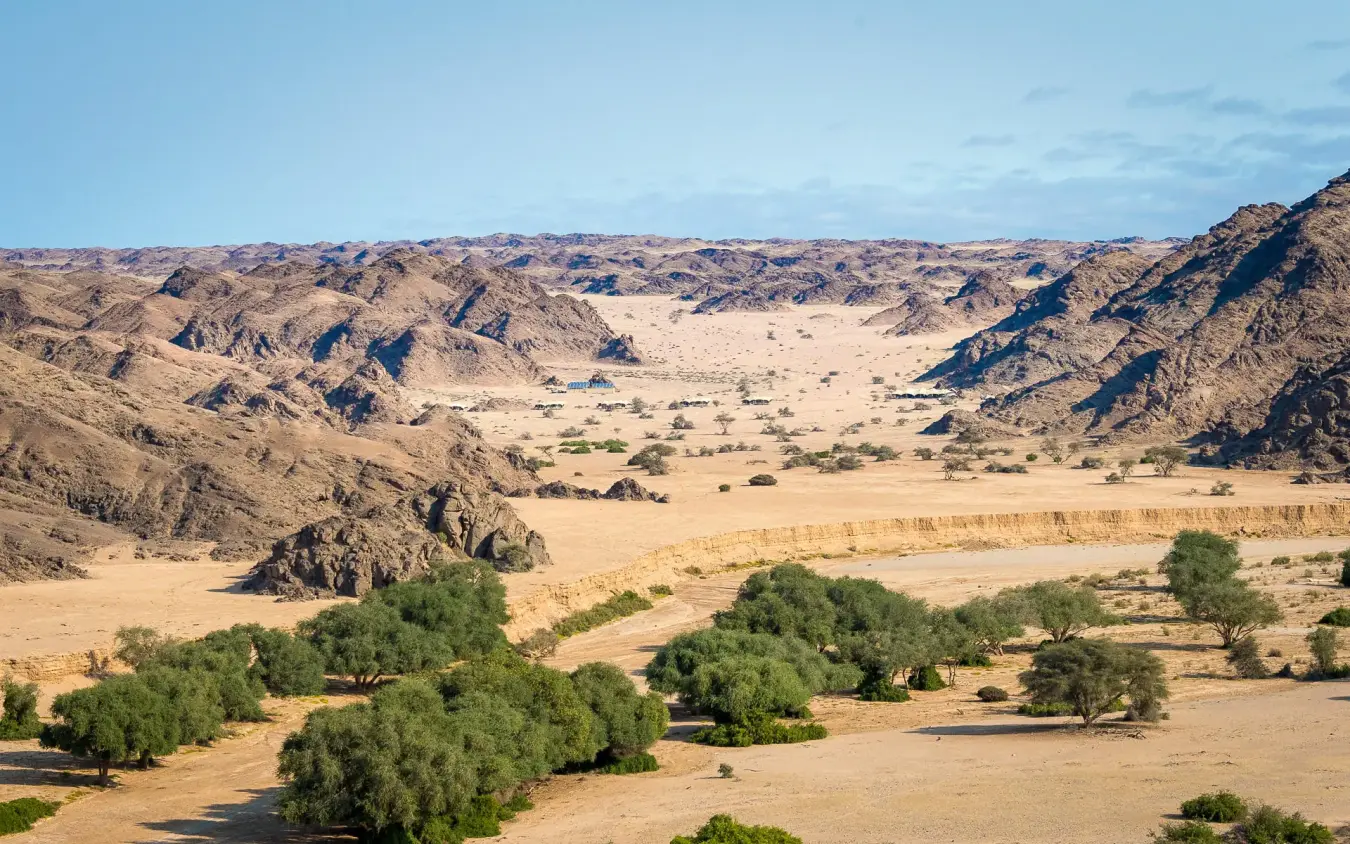Desert valley with river, acacia trees and rocky mountains, Hoanib Skeleton Coast Camp, Skeleton Coast, Namibia