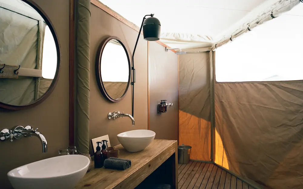 Open-air bathroom with dual vessel sinks and canvas walls, Hoanib Valley Camp, Damaraland, Namibia