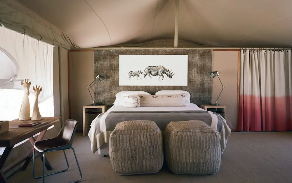 Spacious bedroom with textured headboard and modern furnishings, Hoanib Valley Camp, Damaraland, Namibia