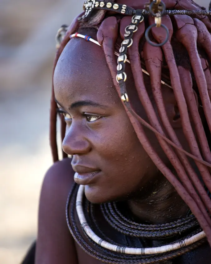 Portrait of woman wearing traditional beaded jewelry and braids, Skeleton Coast, Namibia