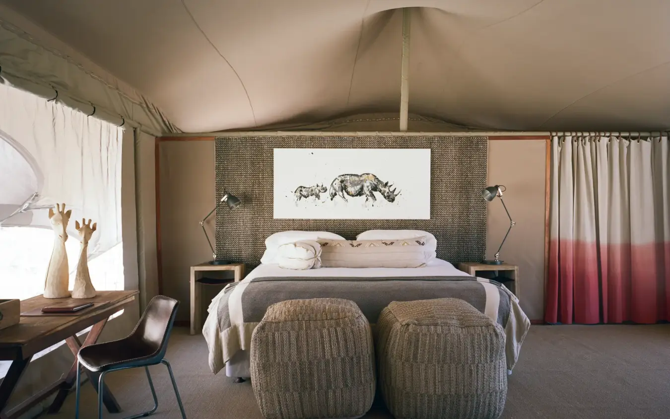 Luxury safari tent bedroom with canvas walls and artwork, Hoanib Valley Camp, Skeleton Coast, Namibia