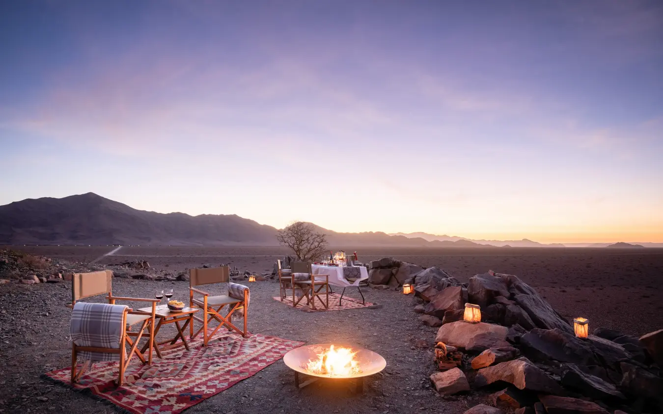 Desert campfire setup with chairs and mountain sunset views, Hoodia Desert Lodge, Sossusvlei, Namibia