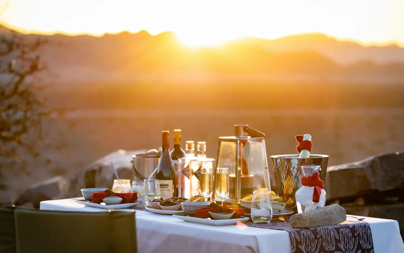 Outdoor dining setup at sunset with desert landscape view, Hoodia Desert Lodge, Sossusvlei, Namibia