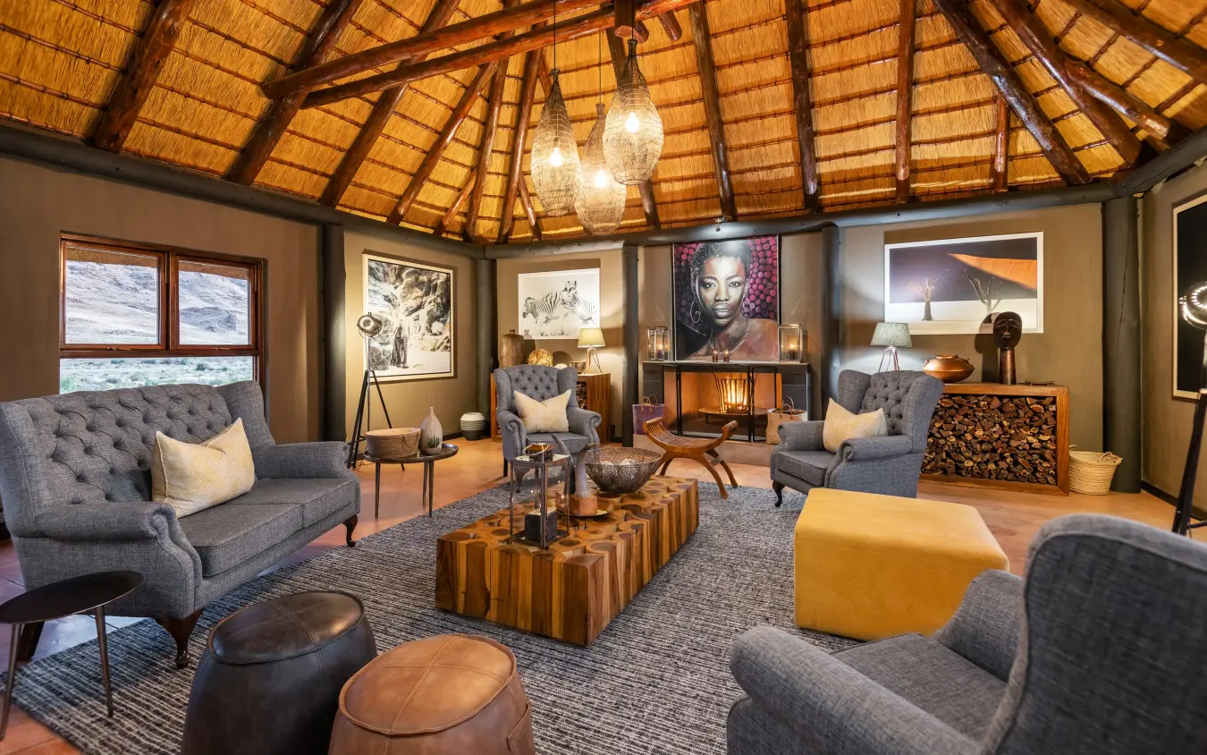Interior lounge with thatched roof and comfortable seating, Hoodia Desert Lodge, Sossusvlei, Namibia