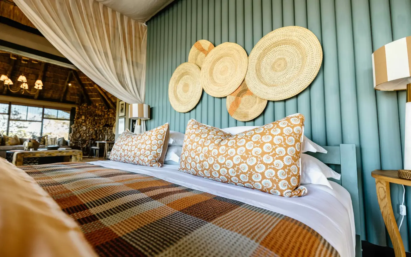 Luxury bedroom with woven wall décor and patterned throw pillows, Horizon by Ongava, Etosha National Park, Namibia