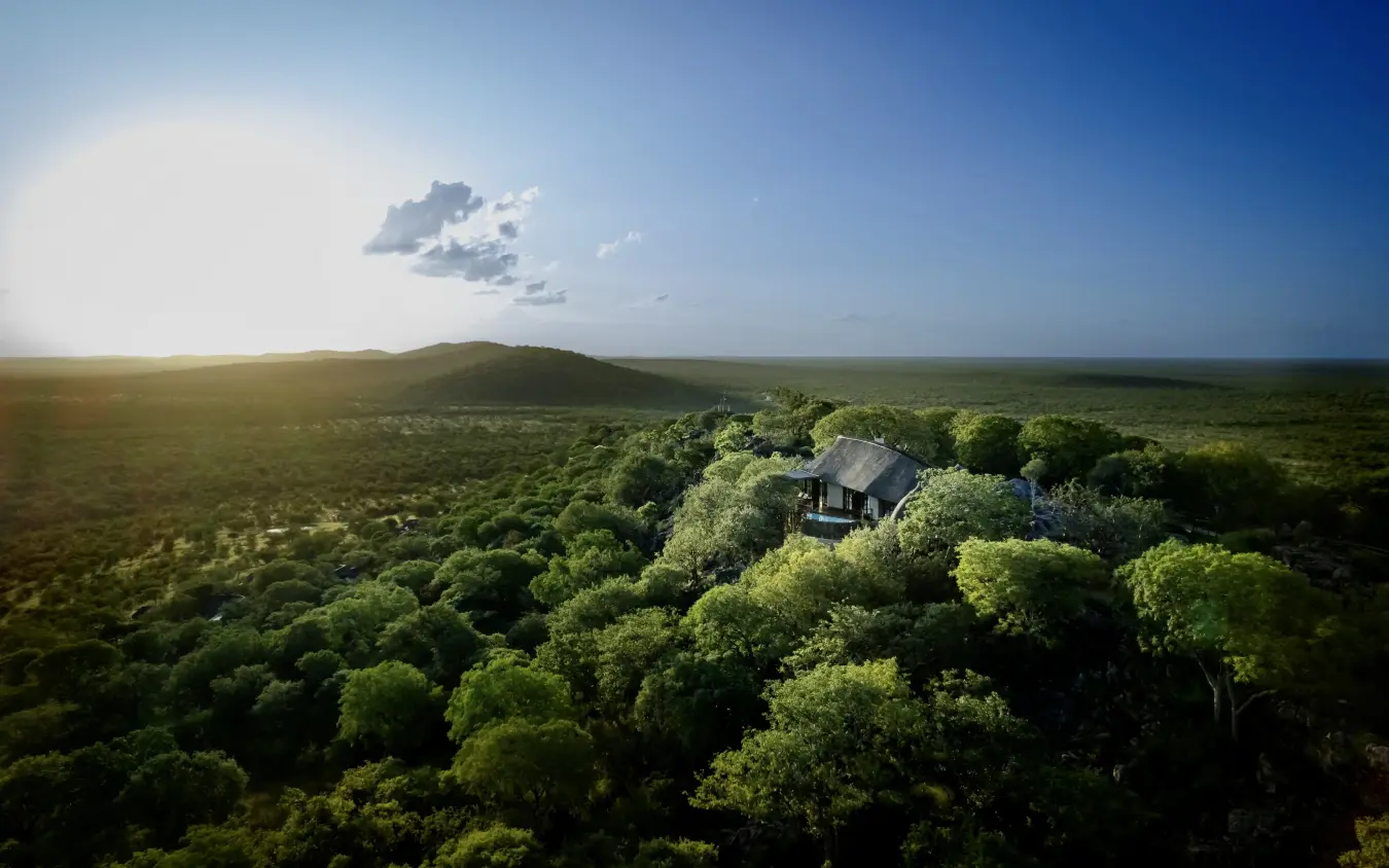 Luxury lodge nestled among dense woodland canopy in remote savanna landscape, Horizon by Ongava, Etosha National Park, Namibia