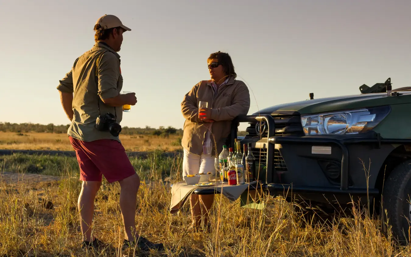Guests enjoying drinks at vehicle during safari stop, Hwange Bush Camp, Hwange National Park, Zimbabwe