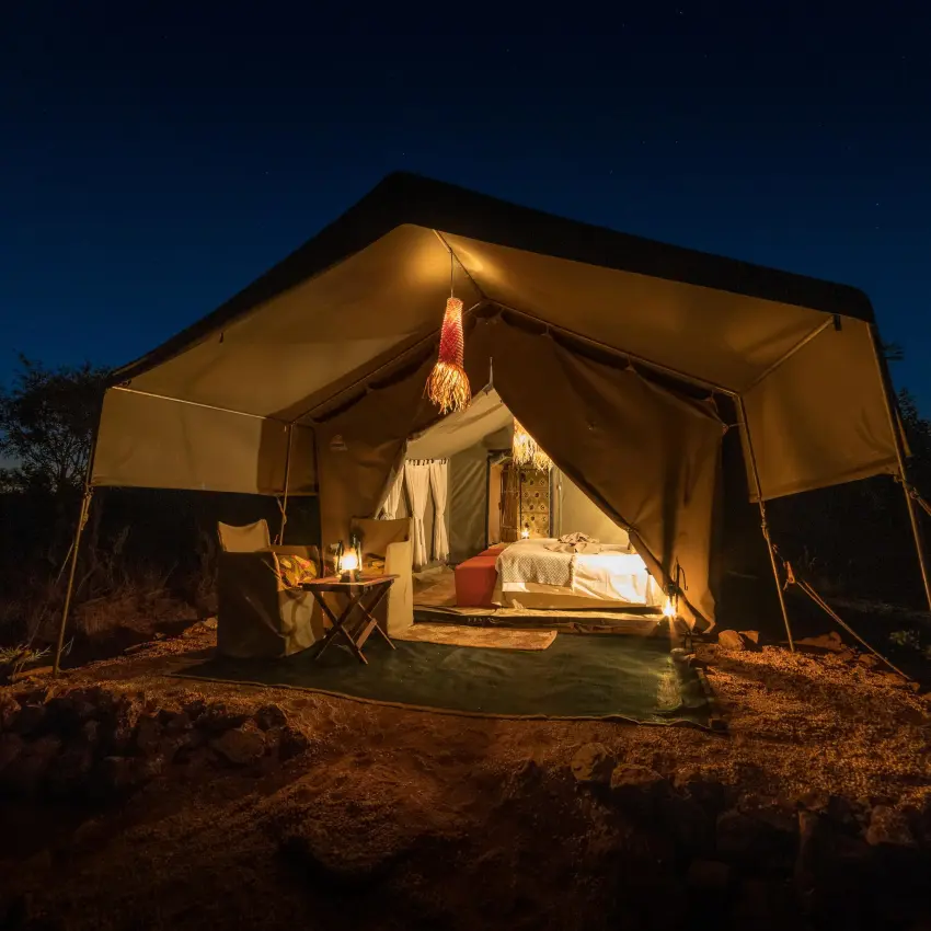 Illuminated canvas safari tent at night in African bush, Hwange Bush Camp, Hwange National Park, Zimbabwe