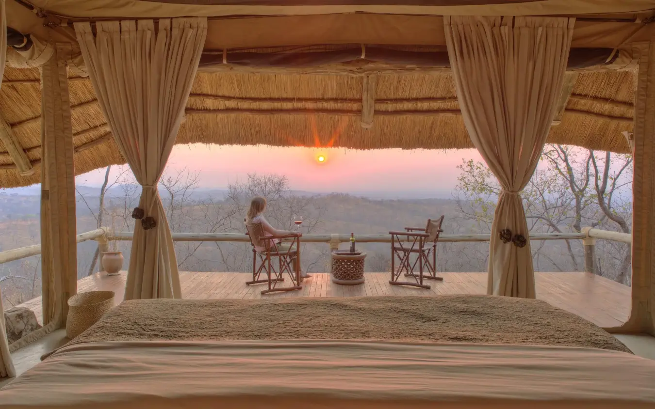 Covered wooden deck overlooking savanna at sunset, Ikuka Safari Camp, Ruaha National Park, Tanzania