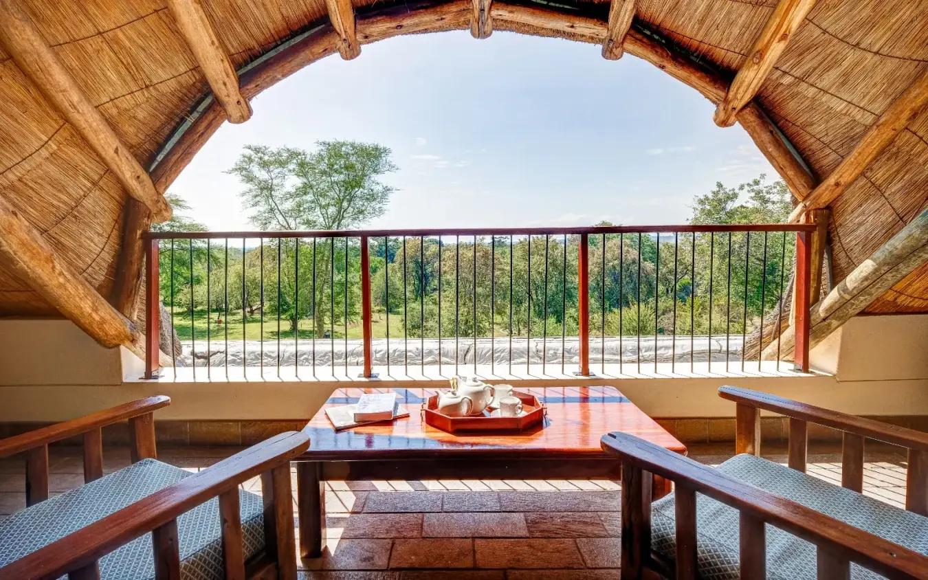 Wooden pavilion with river view and savanna landscape beyond railing, Ilala Lodge Hotel, Victoria Falls, Zimbabwe