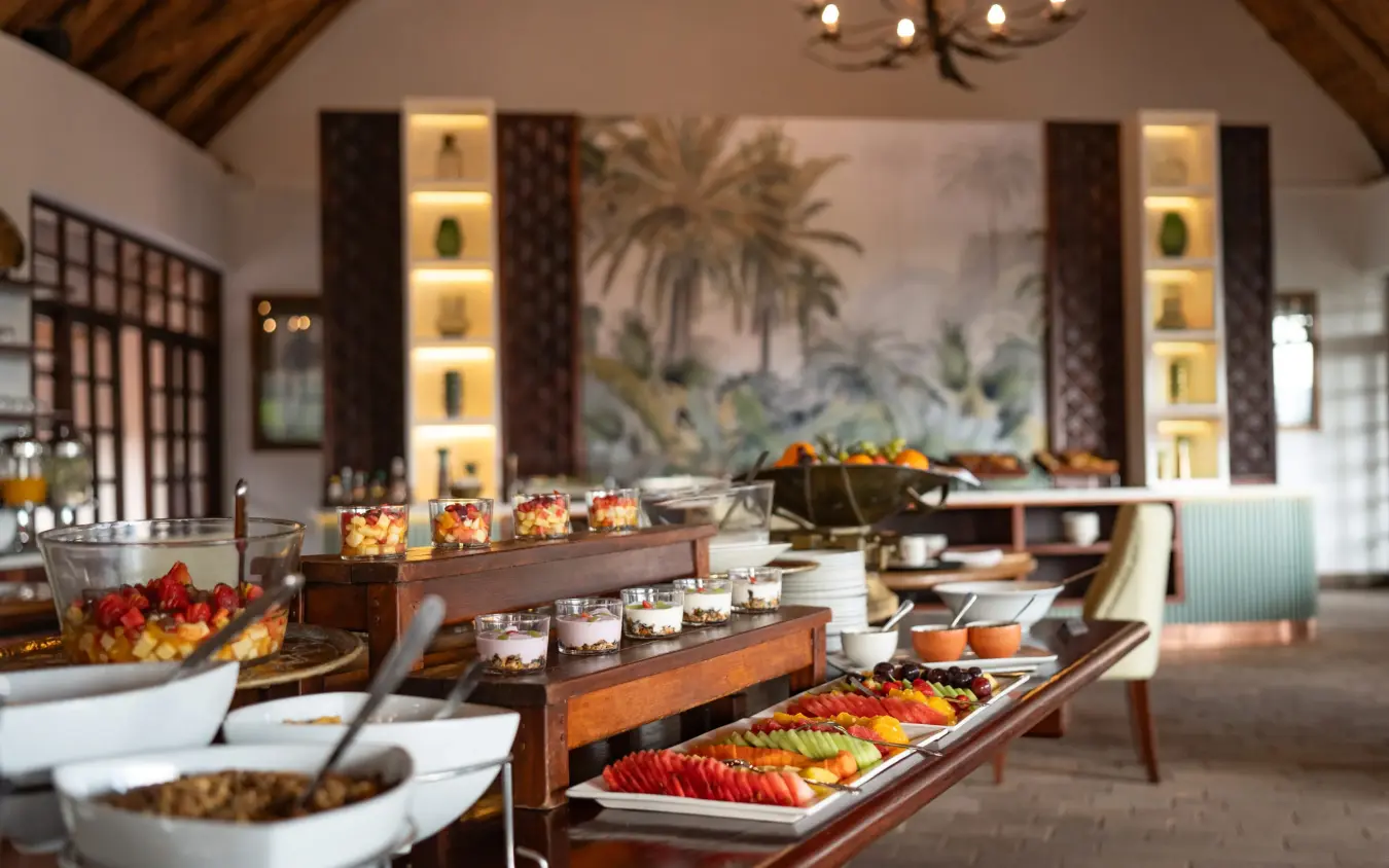 Luxury buffet spread with tropical fruits and illuminated wall displays, Ilala Lodge Hotel, Victoria Falls, Zimbabwe