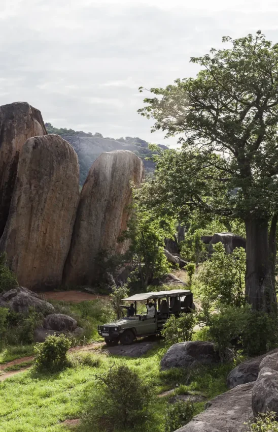 Open-air vehicle tour through rocky landscape with giant boulders, Jabali Private House, Ruaha National Park, Tanzania