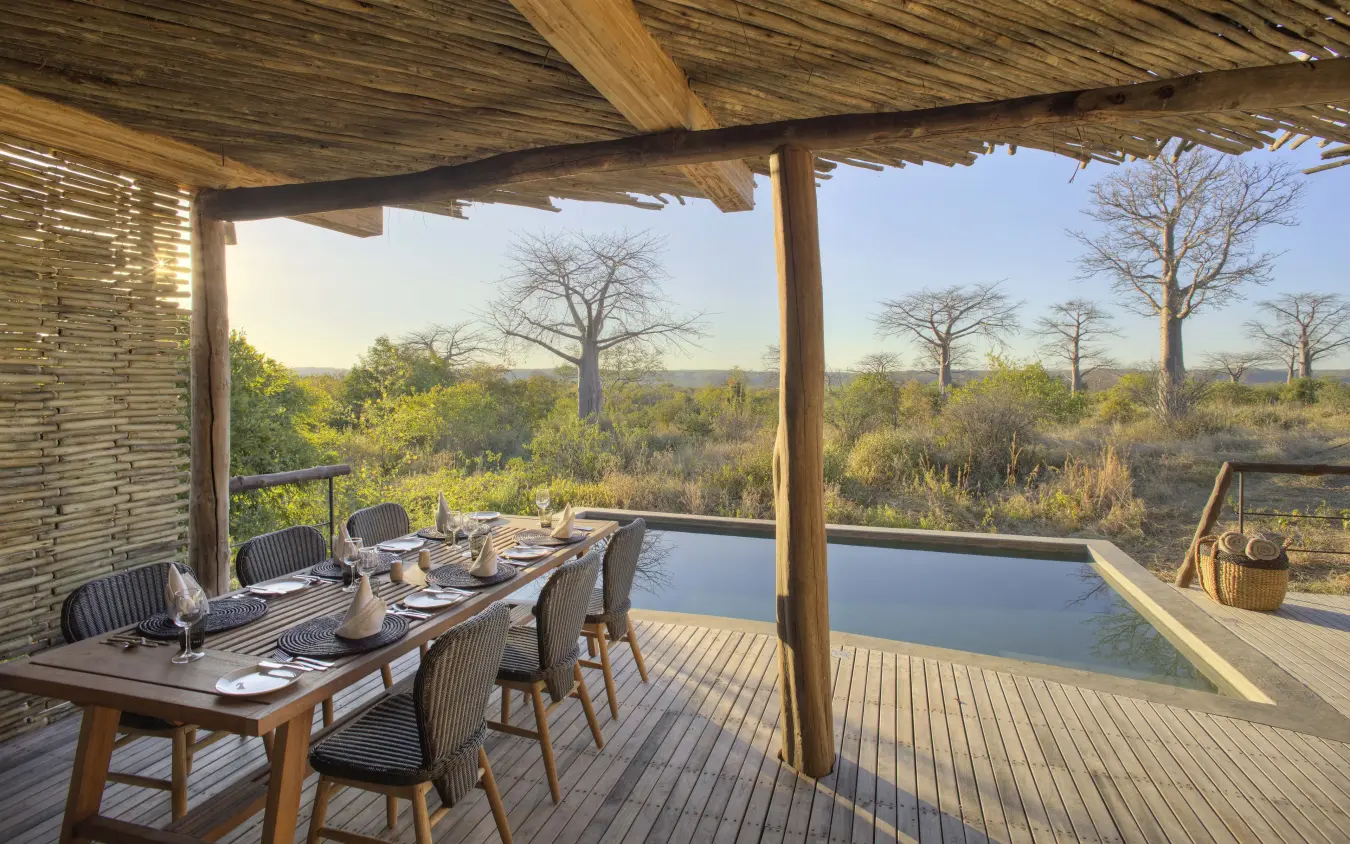 Dining deck overlooking savanna landscape with baobab trees, Jabali Private House, Ruaha National Park, Tanzania