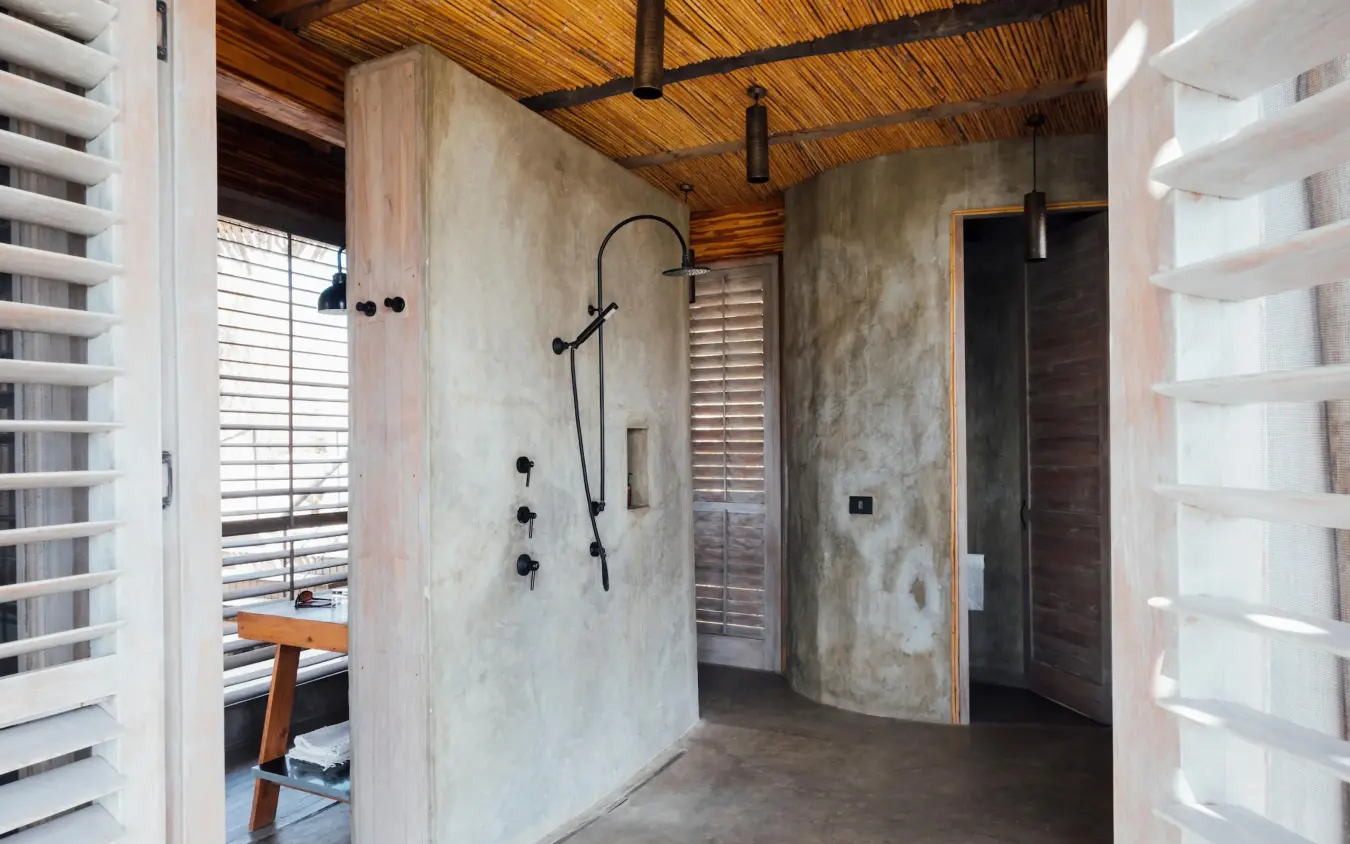 Modern bathroom with concrete walls and black fixtures, Jabali Ridge, Ruaha National Park, Tanzania