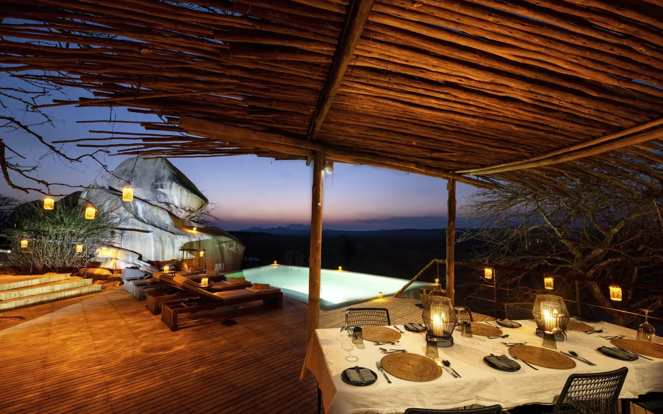 Elevated dining deck with pool and valley view at dusk, Jabali Ridge, Ruaha National Park, Tanzania