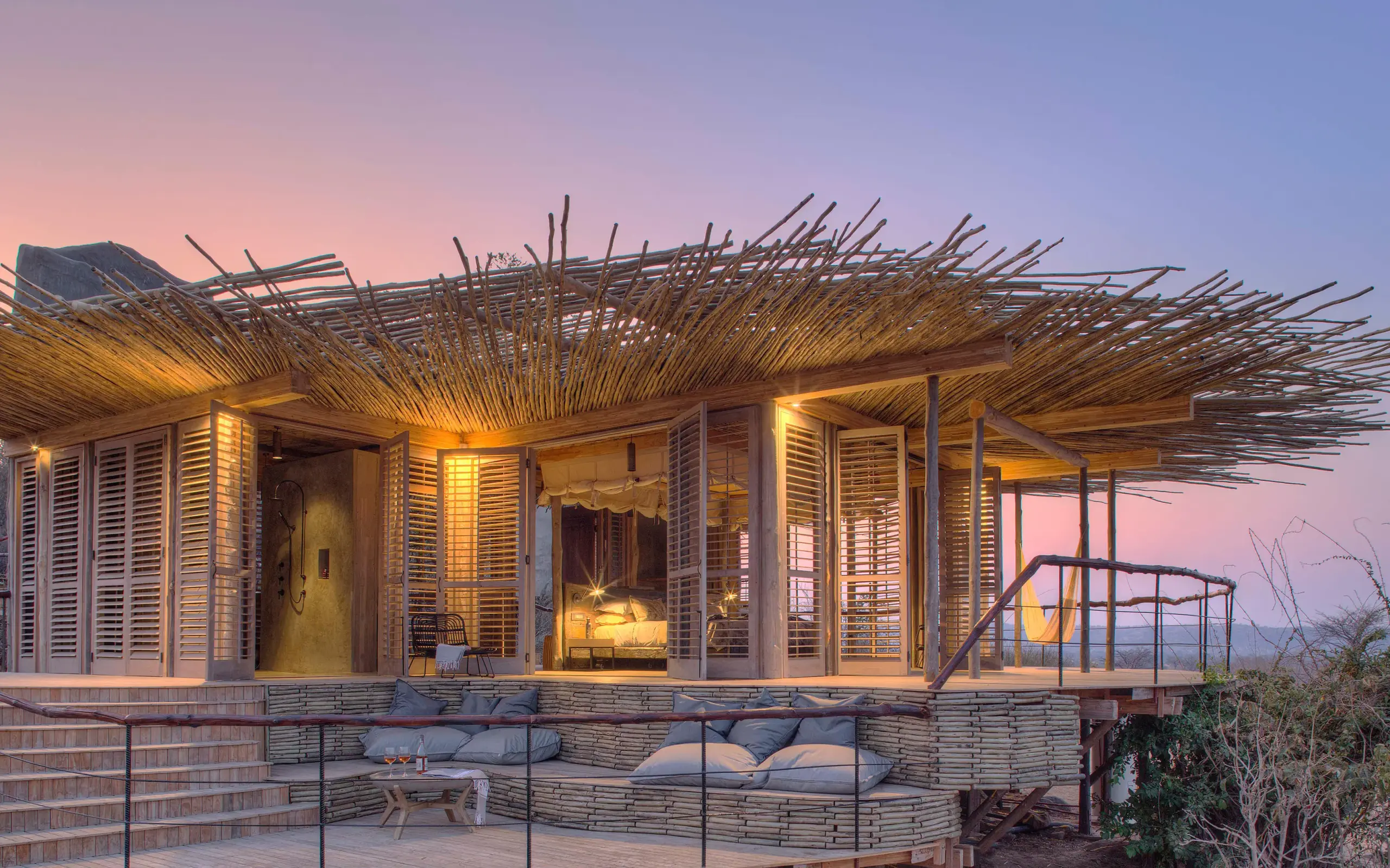 Modern lodge building with thatch roof at sunset, Jabali Ridge, Ruaha National Park, Tanzania